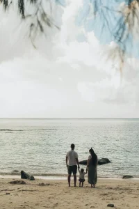 Familia paseando por la orilla del mar – Autorización de viaje de menores al extranjero