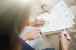 Firma de un documento en la mesa de reuniones de Notaría PG74 – Diferencias entre compraventa y disolución de condominio