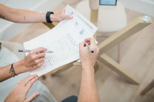 Firma de un documento en la mesa de reuniones de Notaría PG74 – Documentación imprescindible para vender tu casa en Cataluña en 2026
