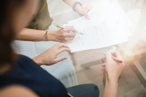 Firma de un documento en la mesa de reuniones de Notaría PG74 – El ITP en la compraventa de viviendas en Cataluña en 2025