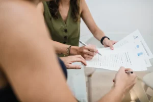 Firma de un documento en la mesa de reuniones de Notaría PG74 – Medios de pago del precio al comprar un inmueble
