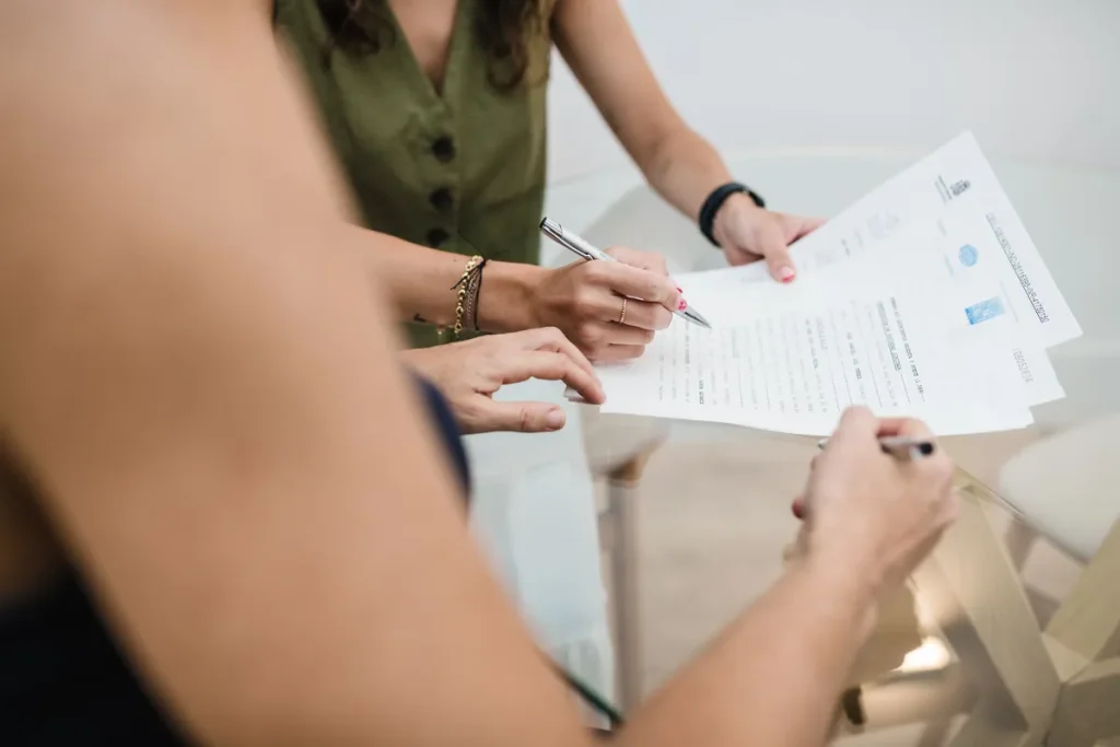 Firma de un documento en la mesa de reuniones de Notaría PG74 – Sociedad Limitada Unipersonal